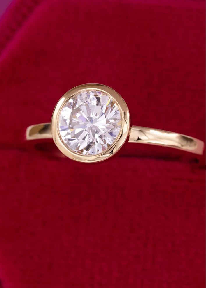 Gold engagement ring with bezel set round brilliant cut diamond