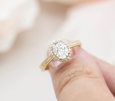 Diamond halo engagement ring on fingertip