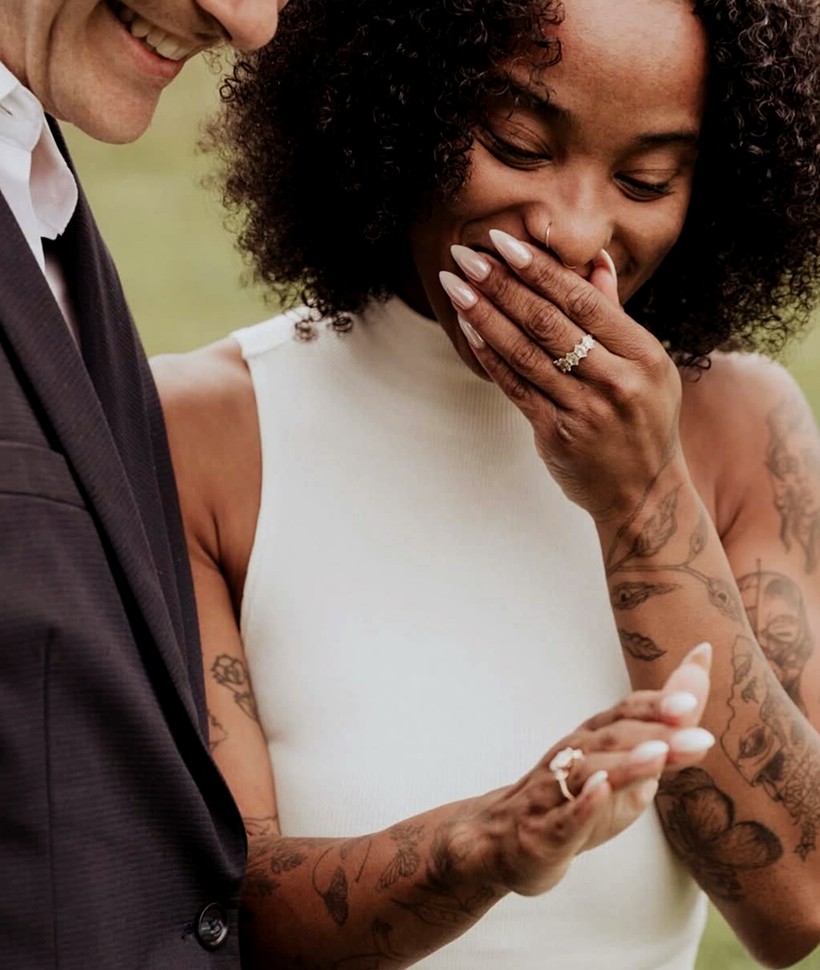 Smiling couple looking at engagement ring
