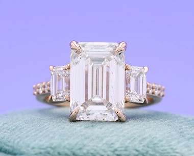 Completed engagement ring with trio of emerald-cut diamonds photographed after design process